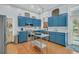 Charming kitchen with blue cabinets, modern stainless-steel appliances, and wood floors at 301 E Richardson Ave, Summerville, SC 29483