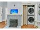 Laundry closet features stacked washer and dryer next to a rustic fireplace at 301 E Richardson Ave, Summerville, SC 29483