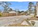 Spacious gravel parking area with wooden fence and mature trees at 301 E Richardson Ave, Summerville, SC 29483