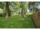 Expansive backyard with mature trees, lush green grass, and a glimpse of the home's exterior at 303 Hamlet Rd, Summerville, SC 29485