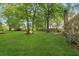 Spacious backyard with lush lawn, mature trees, and partially fenced property at 303 Hamlet Rd, Summerville, SC 29485