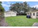 An expansive green backyard with a two-car garage, a home, and a screened-in porch at 305 Driver Ave, Summerville, SC 29483