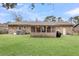 A spacious backyard featuring a brick exterior, a screened-in porch, and ample green space for outdoor activities at 305 Driver Ave, Summerville, SC 29483
