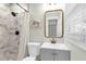 Bathroom with a granite-style shower, gray vanity, and gold mirror accents at 305 Driver Ave, Summerville, SC 29483