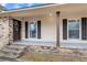 Inviting front porch featuring brick detailing, painted pillars, and a welcoming entrance at 305 Driver Ave, Summerville, SC 29483
