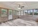 Bright sunroom with abundant windows, painted brick, ceiling fan, and entry door to the yard at 305 Driver Ave, Summerville, SC 29483
