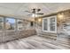 Inviting sunroom featuring brick accent wall, multiple windows, ceiling fan, and stylish flooring at 305 Driver Ave, Summerville, SC 29483