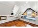 White painted attic with built-in storage, a window seat, and wood floors at 31 Hasell St, Charleston, SC 29401
