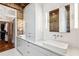 Modern bathroom with double sinks, sleek vanity, exposed brick, and a walk-in closet at 31 Hasell St, Charleston, SC 29401