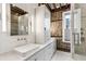 Modern bathroom with double sinks, sleek vanity, exposed brick, and a glass-enclosed shower at 31 Hasell St, Charleston, SC 29401