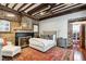Spacious bedroom with exposed brick and beams, a plush rug, fireplace, and abundant natural light at 31 Hasell St, Charleston, SC 29401