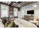 Bright bedroom boasts exposed beams, a full-length mirror, and windows providing ample natural light at 31 Hasell St, Charleston, SC 29401