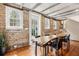 Unique dining area with a natural wood table, exposed brick, and ample natural light at 31 Hasell St, Charleston, SC 29401
