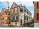 Charming brick home featuring a double porch, blue shutters, and manicured landscaping at 31 Hasell St, Charleston, SC 29401
