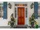 Stunning front door with sidelights, blue shutters, and lantern sconces at 31 Hasell St, Charleston, SC 29401
