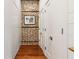 Hallway with hardwood flooring, brick accent wall, and white paneled wall at 31 Hasell St, Charleston, SC 29401