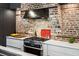 Close-up of kitchen highlighting stainless steel range, custom hood, and marble countertops at 31 Hasell St, Charleston, SC 29401