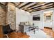 Cozy living room features exposed brick wall, hardwood floors, and a comfortable gray sofa at 31 Hasell St, Charleston, SC 29401