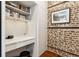 Office nook featuring a built-in desk, and exposed brick accent wall at 31 Hasell St, Charleston, SC 29401