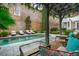 Lounge chairs and other seating adorn a backyard pool and garden at 31 Hasell St, Charleston, SC 29401
