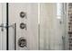 Luxurious shower with chrome fixtures, white tile walls, and exposed brick detailing at 31 Hasell St, Charleston, SC 29401
