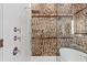 Elegant bathroom featuring a glass-enclosed shower with chrome fixtures and exposed brick accent wall at 31 Hasell St, Charleston, SC 29401