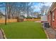 Large backyard featuring a storage shed, a newly installed fence, a brick house and a well manicured lawn at 312 Mary Scott Dr, Goose Creek, SC 29445