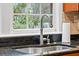 Close up of kitchen sink featuring granite countertop, modern faucet, and window view at 3216 Rose Walk Ct, Mount Pleasant, SC 29466
