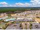 Stunning aerial view of the community clubhouse, pool, and lush landscaping in a neighborhood setting with ponds and wooded areas at 323 Waterlily Way, Summerville, SC 29486