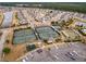Aerial view of a community featuring tennis courts, bocce ball, and a playground, surrounded by homes and ponds at 323 Waterlily Way, Summerville, SC 29486