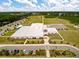 Aerial view of a large community center with ample parking and sports fields surrounded by mature trees at 323 Waterlily Way, Summerville, SC 29486
