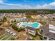 An aerial view of the community pool and amenity center with a pond and treeline in the background at 323 Waterlily Way, Summerville, SC 29486