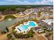 Scenic aerial of a community pool and amenity center overlooking a picturesque pond and beautiful surrounding neighborhood at 323 Waterlily Way, Summerville, SC 29486