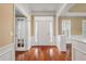 Inviting foyer featuring hardwood floors, a white front door with sidelights, and classic trim details at 323 Waterlily Way, Summerville, SC 29486