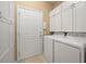 Neat and organized laundry room with white cabinetry and tiled flooring at 323 Waterlily Way, Summerville, SC 29486