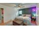 A modern bedroom with unique dark paneling wall, ceiling fan and hardwood floors at 3351 Londonderry Rd, North Charleston, SC 29420