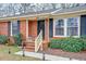 Inviting brick home entrance with black shutters, neat landscaping, and walkway lighting at 3351 Londonderry Rd, North Charleston, SC 29420