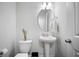 Charming powder room featuring a pedestal sink, oval mirror, and neutral decor at 352 Great Lawn Dr, Summerville, SC 29486