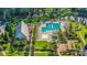 Aerial view of a community pool with palm trees, lounge chairs, a covered pavilion, playground, and a tranquil pond at 352 Great Lawn Dr, Summerville, SC 29486