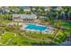 A community pool with palm trees, lounge chairs, and cabanas, surrounded by lush green grass and a pond at 352 Great Lawn Dr, Summerville, SC 29486