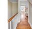 Upstairs hallway with hardwood floors overlooking a bedroom with an upholstered bed at 38 Elliott St, Charleston, SC 29401