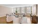 Bright living room with neutral sofas and chairs, a glass coffee table, and hardwood floors at 38 Elliott St, Charleston, SC 29401