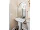 Charming powder room with pedestal sink, decorative mirror, and patterned wallpaper at 38 Elliott St, Charleston, SC 29401