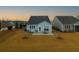 A home's backyard featuring a cozy patio set, well-maintained lawn, and privacy trees at 402 Switchgrass Dr, Summerville, SC 29486