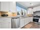 Bright kitchen featuring white cabinets, stainless steel appliances and large windows at 402 Switchgrass Dr, Summerville, SC 29486