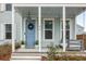 Cozy front porch features a blue front door, a swing, and tasteful landscaping at 46 Clearblue Loop, Summerville, SC 29486