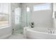 This is a spacious bathroom with marble tiling, a large bathtub, and a glass shower at 46 Clearblue Loop, Summerville, SC 29486