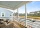 Covered porch features wood flooring and two armchairs, overlooking nature view and a small pond at 46 Clearblue Loop, Summerville, SC 29486