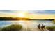 Scenic lake view with a couple sitting on chairs enjoying the golden sunset at 500 Eagleview Dr, Moncks Corner, SC 29461