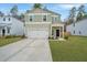 Two story home boasts a white garage door, an inviting covered front porch, and lush green lawn at 500 Minim St, Charleston, SC 29414